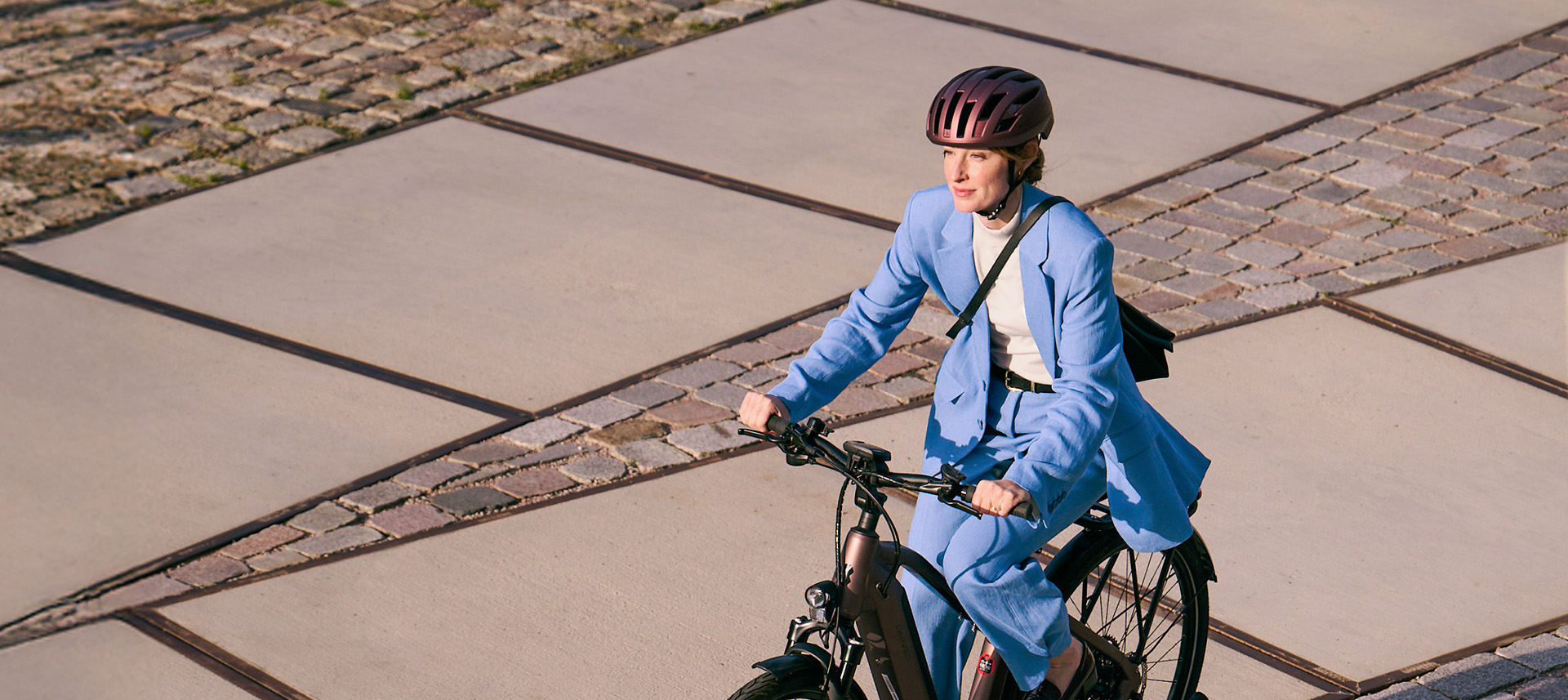 Frau in blauem Businessanzug auf Dienstrad