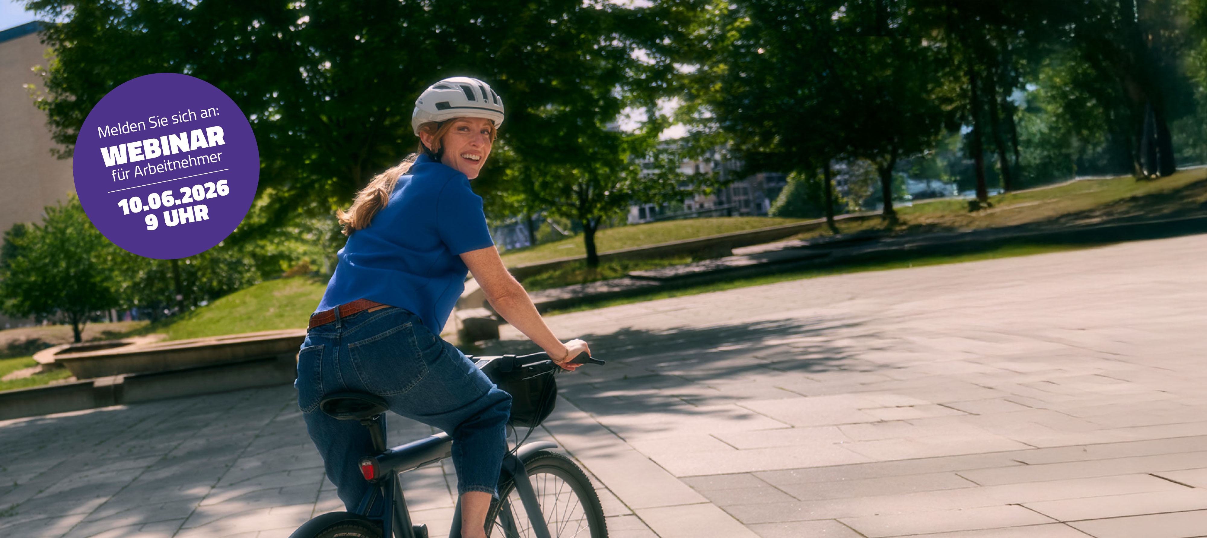 Frau mit Fahrradhelm fährt auf einem Fahrrad durch einen Park und blickt lächelnd zurück; links ist ein violetter Kreis mit dem Text „Melden Sie sich an: Webinar für Arbeitnehmer, 10.06.2026, 9 Uhr“.