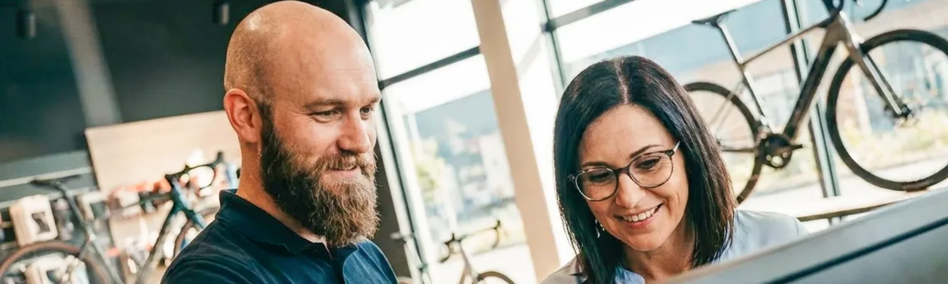 Radhändler im Gespräch mit Kundin vor PC