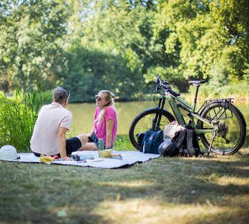 Mann und Frau mit Rädern bei Picknick im Park