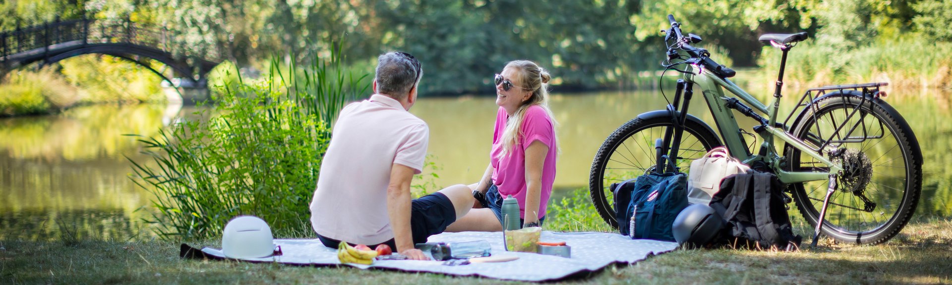 Dienstrad Privatnutzung Mann und Frau mit Rädern bei Picknick im Park