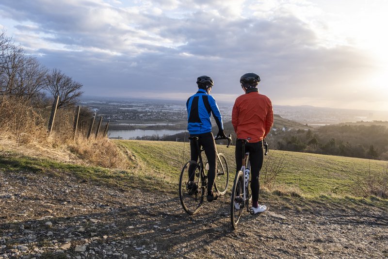 Dienstradfahrer mit geleasten Rennrädern und Blick über die Donau