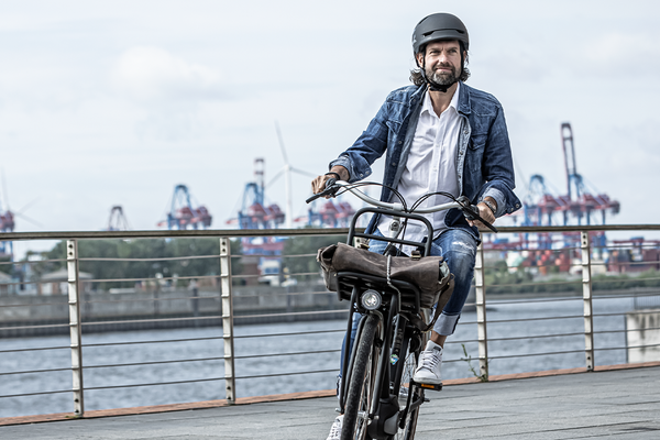 Mann auf Fahrrad in einem Hafen
