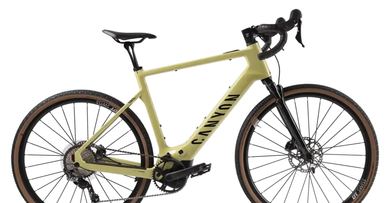 Seitenansicht eines hellgrünen Canyon Gravel-E-Bikes mit Dropbar-Lenker, Scheibenbremsen und braunen Reifenflanken vor hellem Hintergrund.