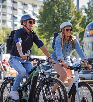 Mann und Frau auf E-Bikes in der Stadt
