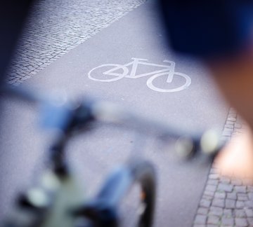 Nahaufnahme eines Radwegs über Fahrradlenker hinweg