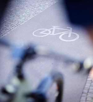 Nahaufnahme eines Radwegs über Fahrradlenker hinweg