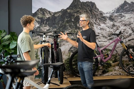 Händler berät Kunden im Shop beim Fahrradkauf