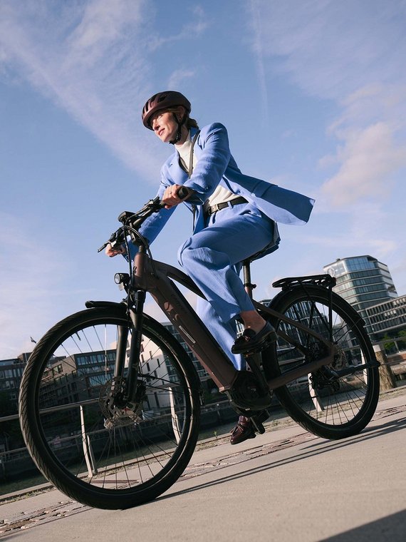 Frau mit E-Bike fährt durch die Stadt