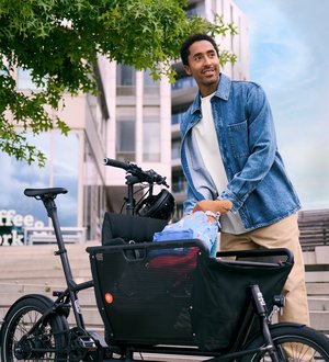 Mann in städtischer Umgebung belädt Lastenrad