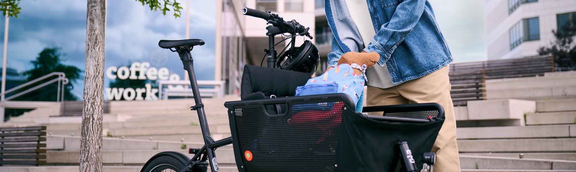 Mann in städtischer Umgebung belädt Lastenrad