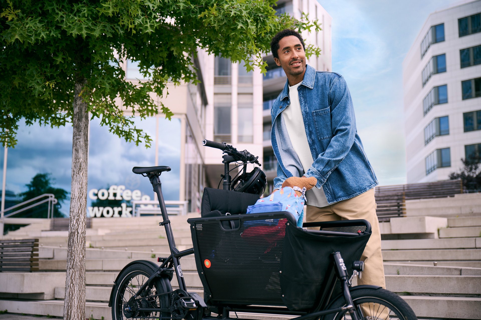 Anhänger oder Lastenrad? Mann in städtischer Umgebung belädt Lastenrad