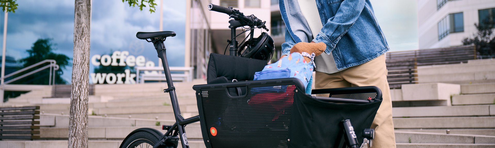 Anhänger oder Lastenrad? Mann in städtischer Umgebung belädt Lastenrad