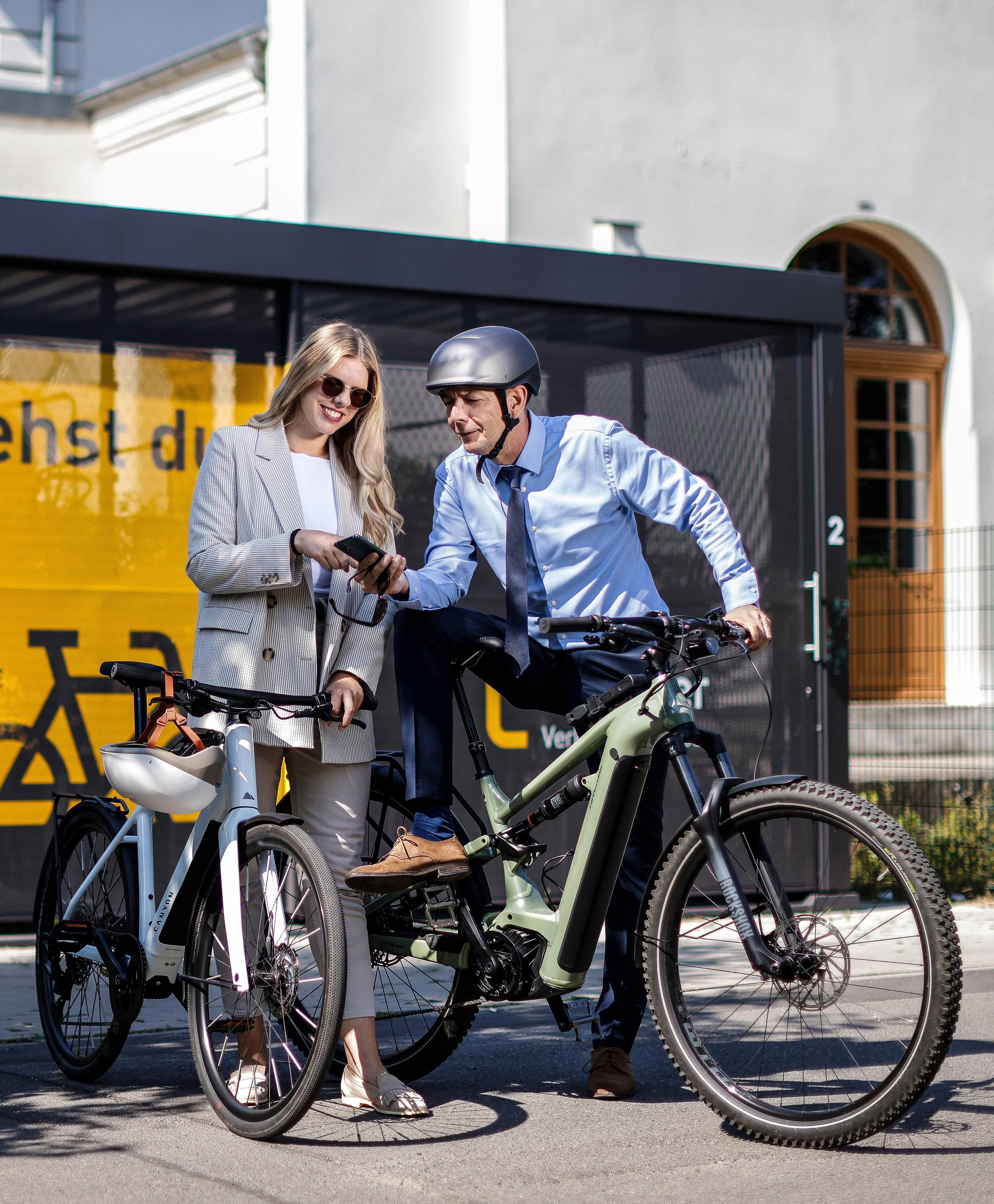 Dienstrad-Leasing für KMU Radfahrerin und Radfahrer mit Smartphone