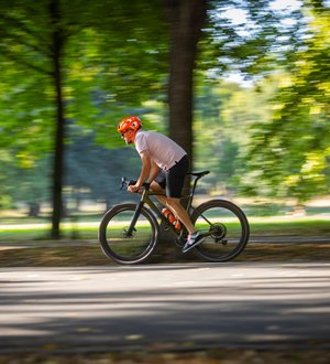 Mann auf Rennrad in Allee