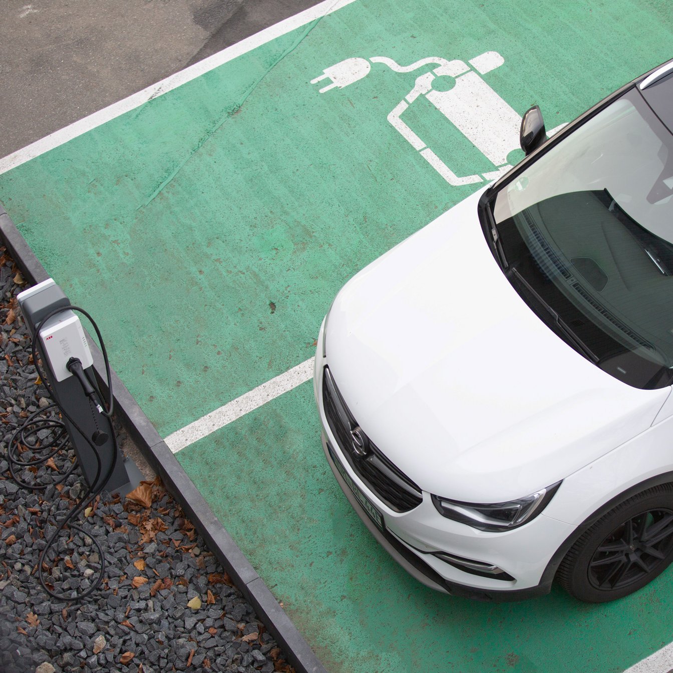 Elektroauto steht auf Parkplatz mit Ladesäule