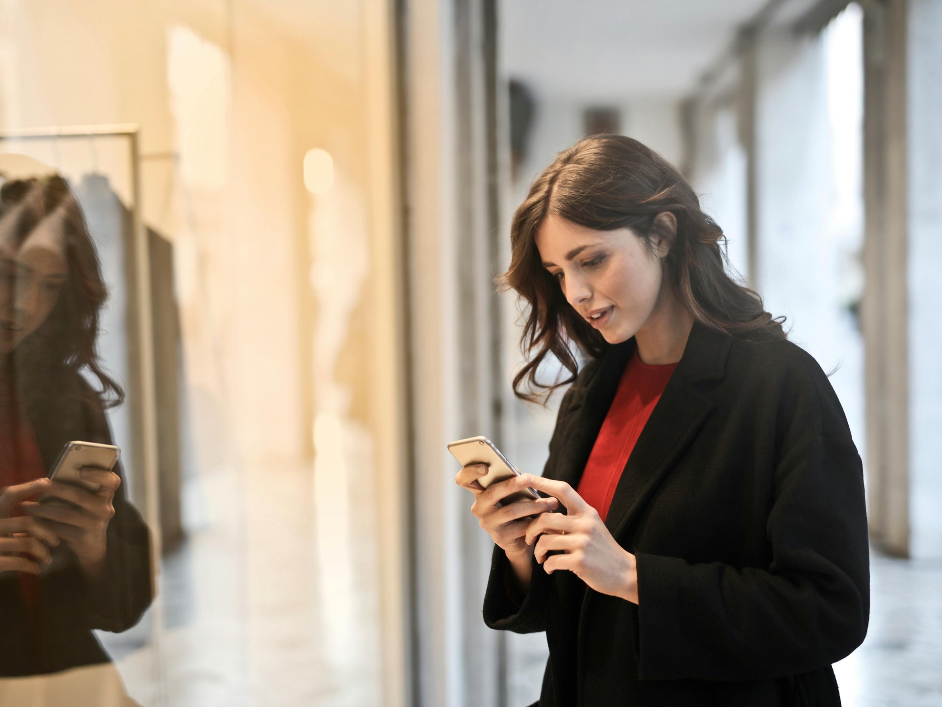 Frau vor Schaufenster am Handy