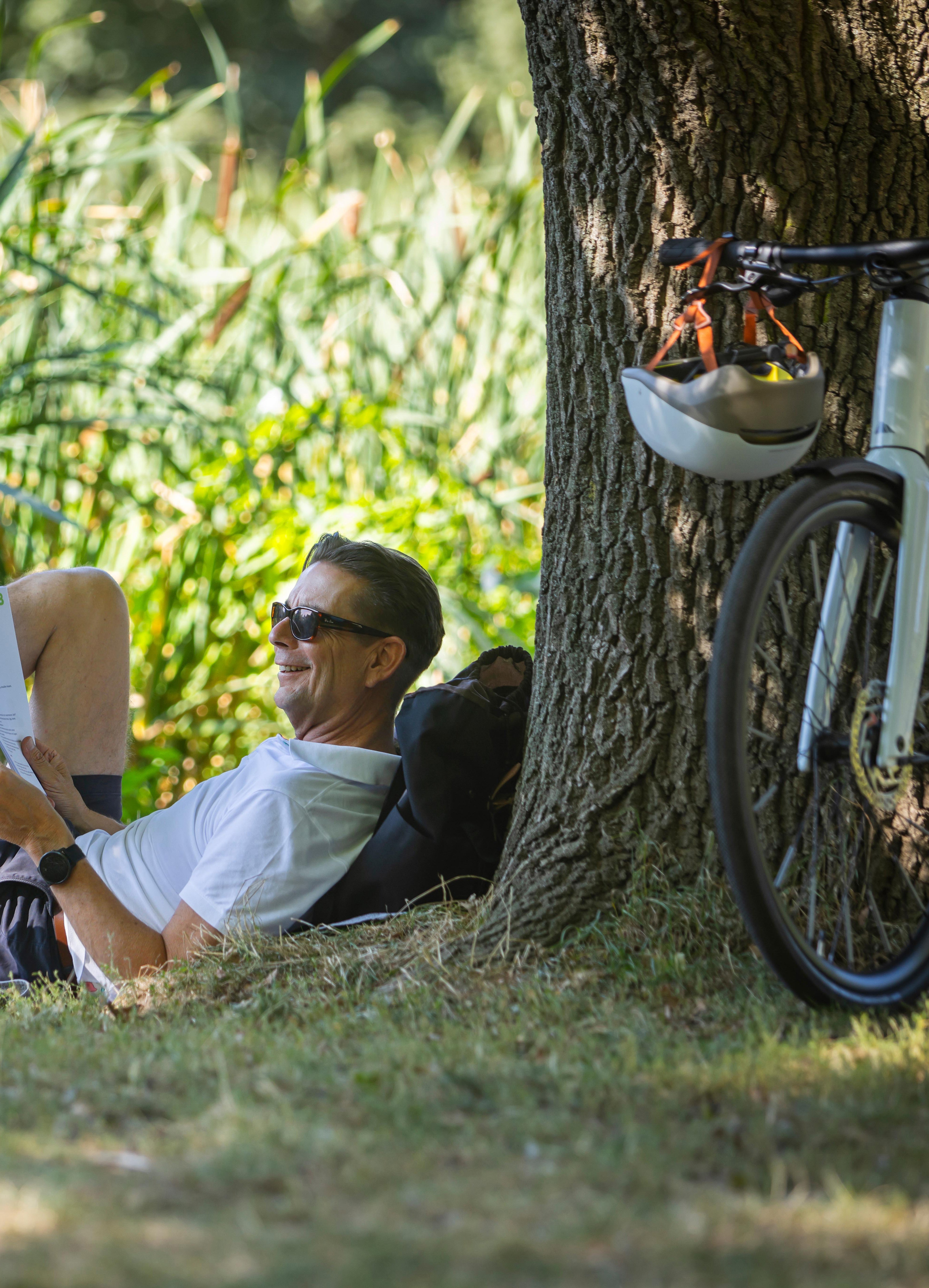 Bikeleasing für Selbständige Mann mit Dienstrad und Unterlagen im Park