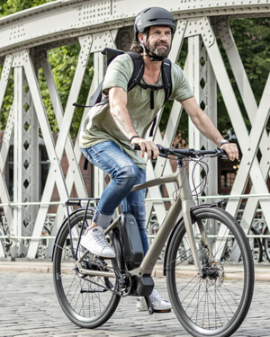 Mann mit Stadtrad auf Brücke