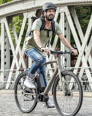 Mann mit Stadtrad auf Brücke