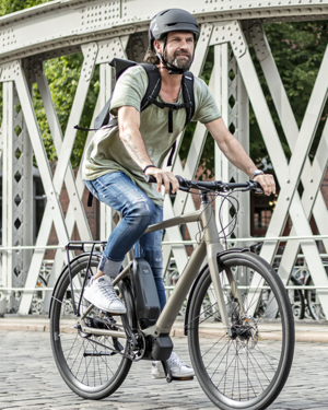Mann mit Stadtrad auf Brücke
