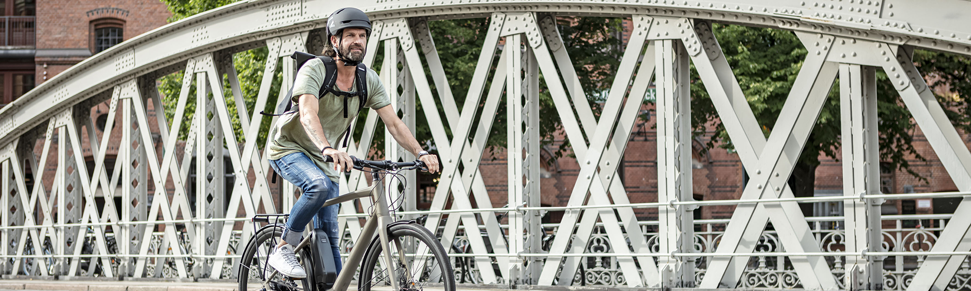 Mann mit Stadtrad auf Brücke