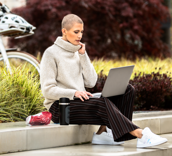 Frau mit Laptop und eBike im Hintergrund
