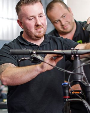 Zwei Fahrradmechaniker arbeiten an Mountainbike