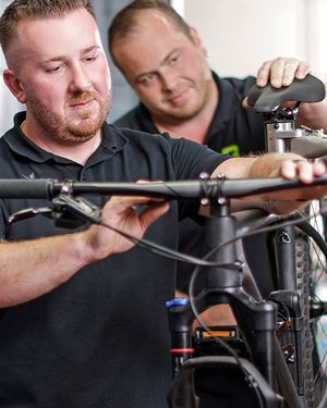 Zwei Fahrradmechaniker arbeiten an Mountainbike