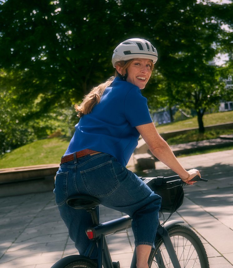 Frau auf Stadtrad blickt über die Schulter in die Kamera