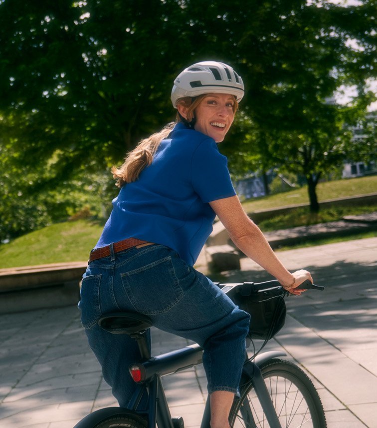 Frau auf Stadtrad blickt über die Schulter in die Kamera