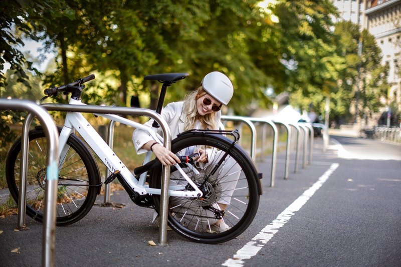Frau schließt eBike an Radabstellablage ab