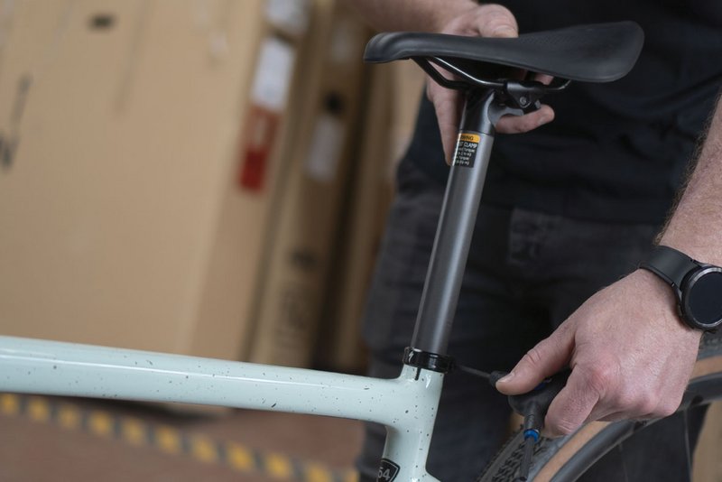 Mechaniker zieht Schraube an der Sattelstütze fest