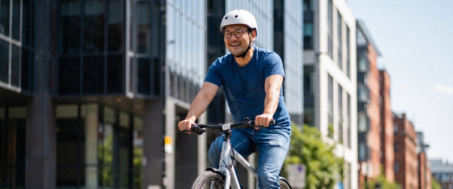 Mann fährt auf Fitnessbike durch Stadt