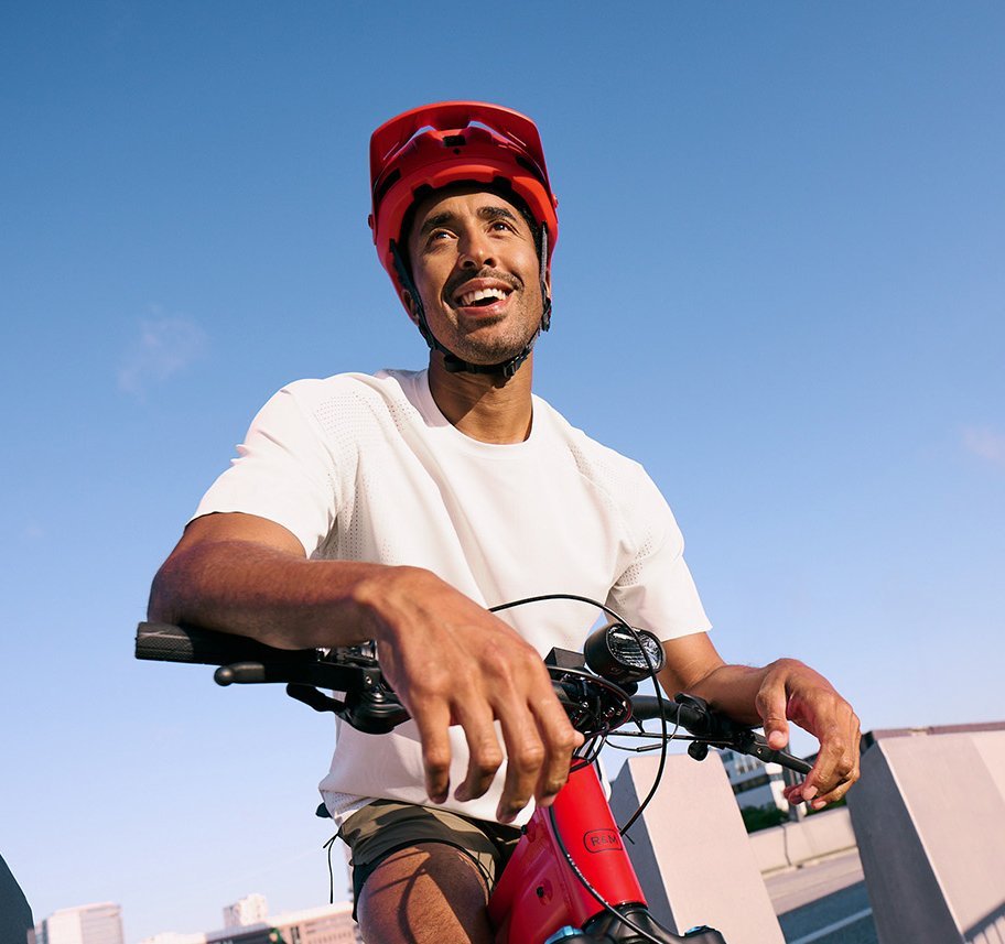 Mann lehnt sich auf Mountainbike-Lenker in städtischer Umgebung